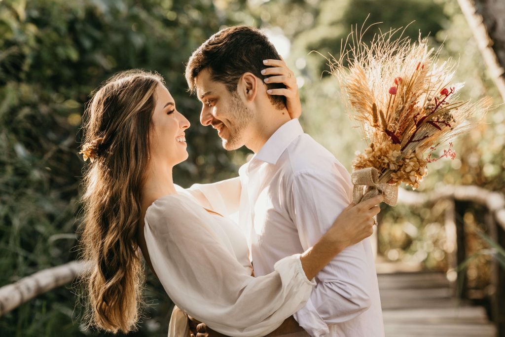 A married couple stand face to face happily embracing thanks to their improved bond formed in Marriage Counseling in Boca Raton, FL.