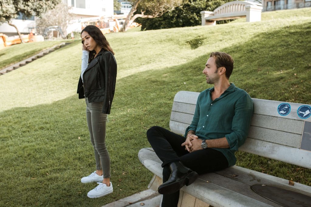 A couple stands apart as they struggle to connect while standing outside representing sa couple who could benefit from Marriage Counseling in Boca Raton, FL.